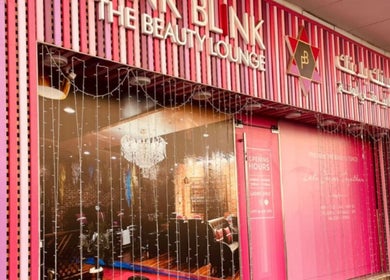 Exterior of Pink Blink The Beauty Lounge in Dubai, AE, showcasing vibrant pink decor and stylish branding.