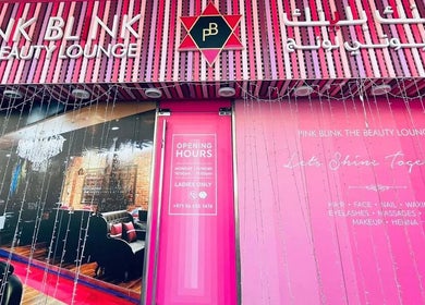Entrance of Pink Blink The Beauty Lounge in Dubai, AE with vibrant pink decor and logo signage.