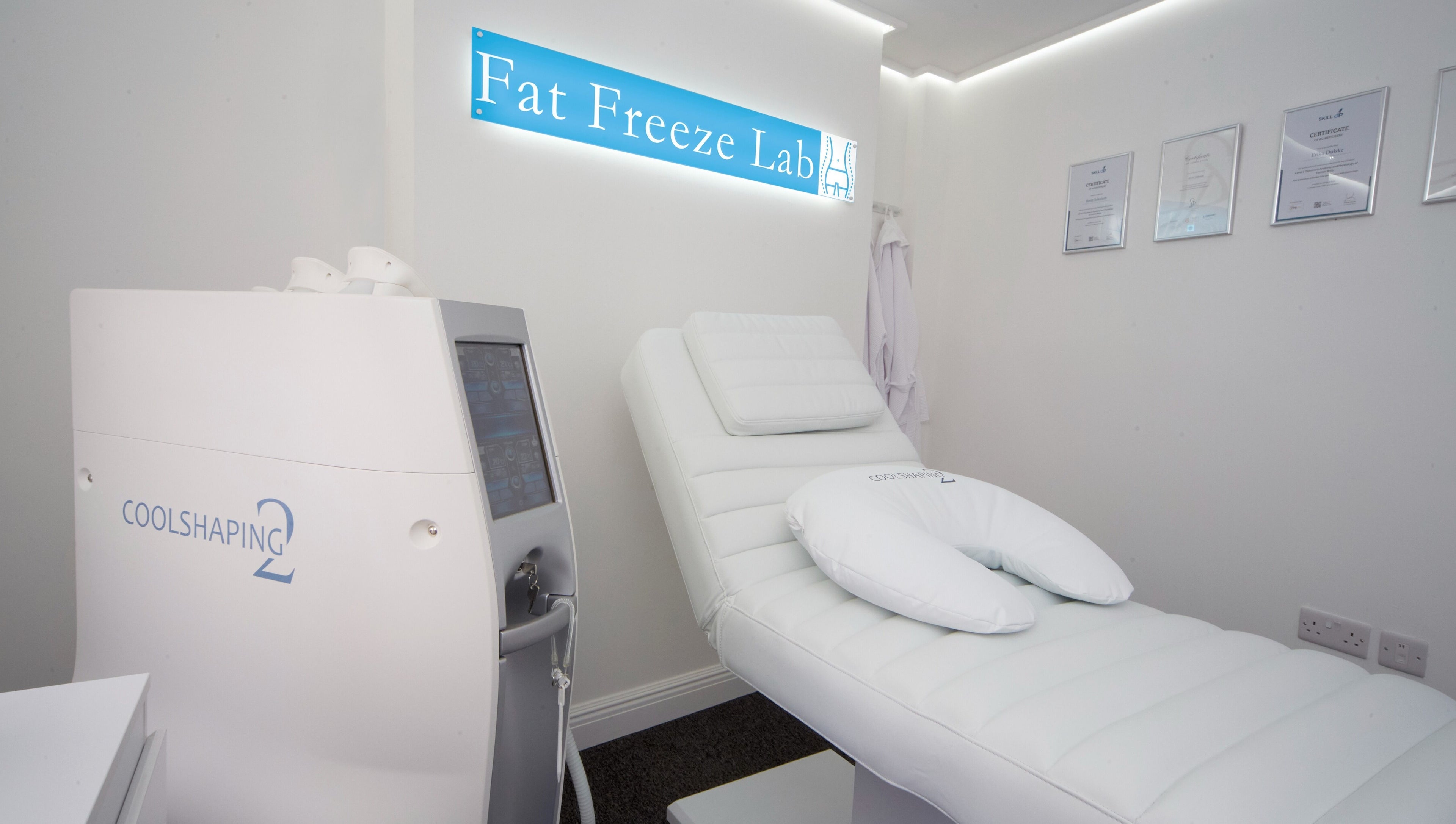 Fat Freeze Lab's sleek treatment room in Hertford, England, GB, featuring CoolShaping equipment and cozy bed.