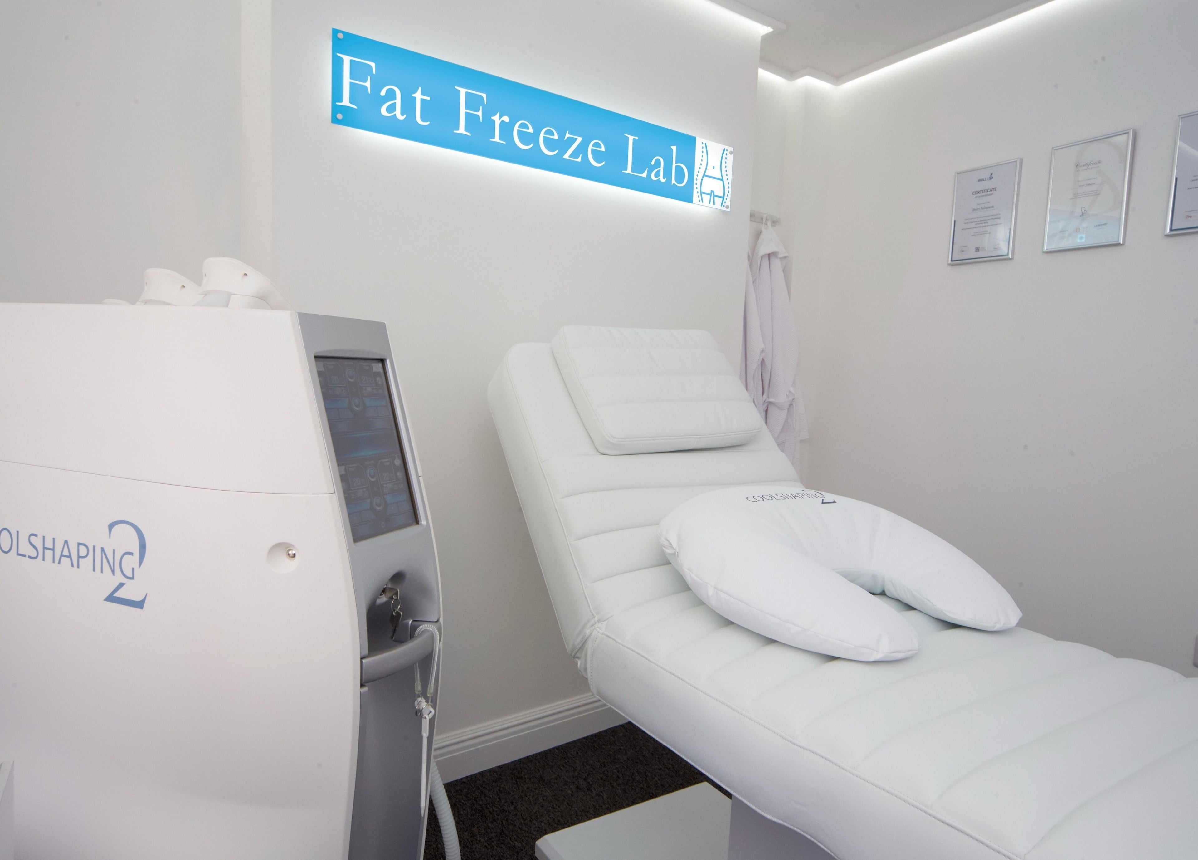Fat Freeze Lab's sleek treatment room in Hertford, England, GB, featuring CoolShaping equipment and cozy bed.