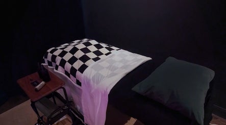 Relaxing massage table at Otta Massage, Glasgow, Scotland, GB, featuring a checkered blanket and ambient lighting.
