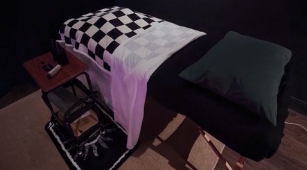 Relaxing massage table at Otta Massage, Glasgow, Scotland, GB, with a checkered blanket and side table.