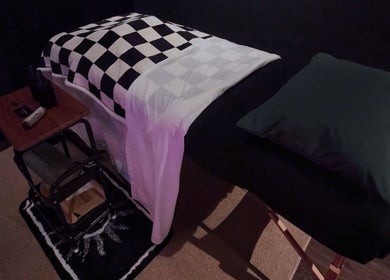 Relaxing massage table at Otta Massage in Glasgow, Scotland, GB with a checkered blanket and dim lighting.