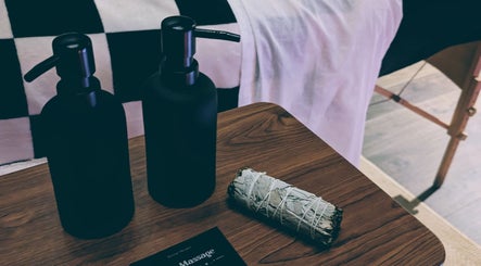 Massage lotions and sage bundle on a wooden table at Otta Massage, Glasgow, Scotland, GB.