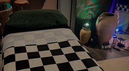 Tranquil massage room at Otta Massage, Glasgow, Scotland, GB with checkered decor and calming ambiance.