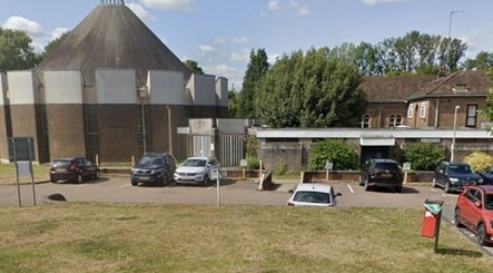Front of Hollies Beauty Room in Hatfield, England, GB with parking and greenery around.