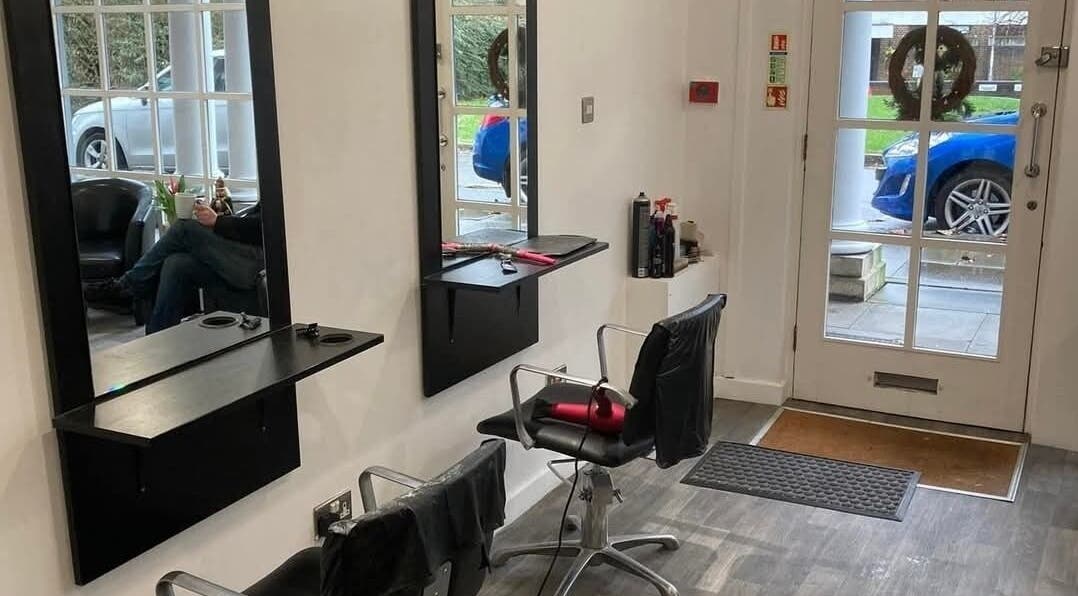Modern salon interior at Hollies Beauty Room in Hatfield, England, GB showing styling chairs and mirrors.