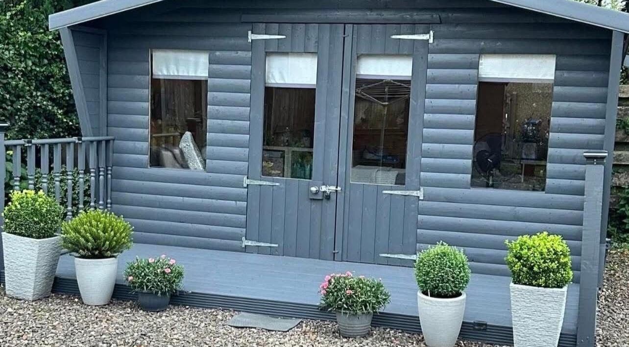 Kirsty’s Beauty Cabin in Cowdenbeath, Scotland. Cozy exterior with potted plants and rustic charm.