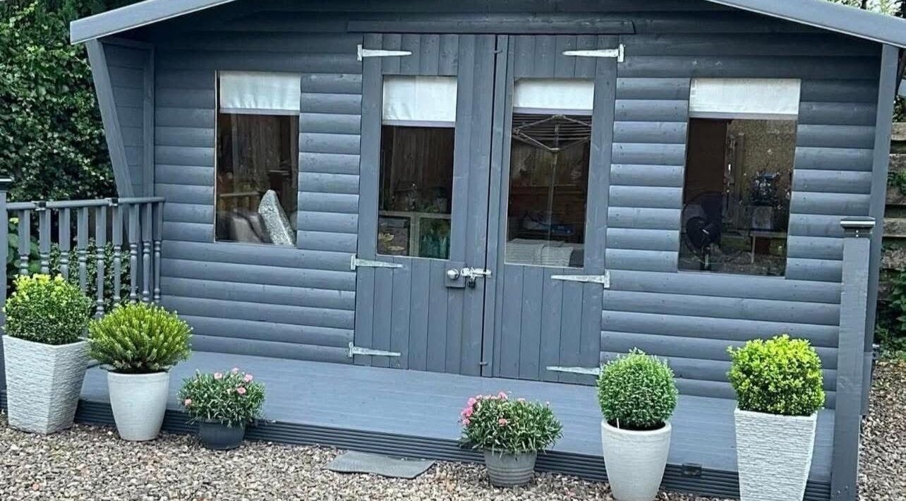 Kirsty’s Beauty Cabin in Cowdenbeath, Scotland. Cozy exterior with potted plants and rustic charm.