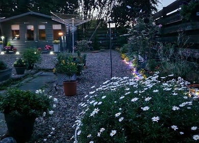 Charming night view of Kirsty’s Beauty Cabin's illuminated garden in Cowdenbeath, Scotland, GB.