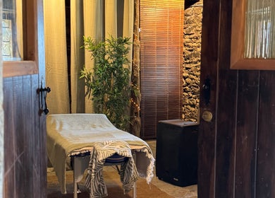 Sala de masaje acogedora en Hub de Bienestar GRS, Graus, Aragón, ES, con mesa y decoración natural.