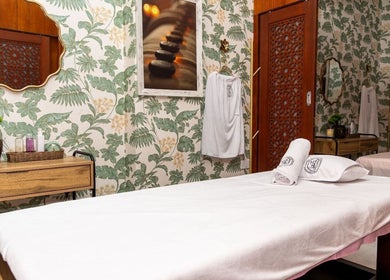 Elegant spa room at Maison De Beauté, Doha, Doha, QA with floral wallpaper and massage bed.