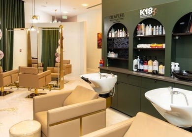 Elegant salon interior at Maison De Beauté, Doha, Doha, QA, featuring plush chairs and styling products.