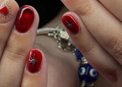 Manicura roja con diseño de estrella y corazón en Bel Studio Castelar, Morón, Provincia De Buenos Aires, AR.