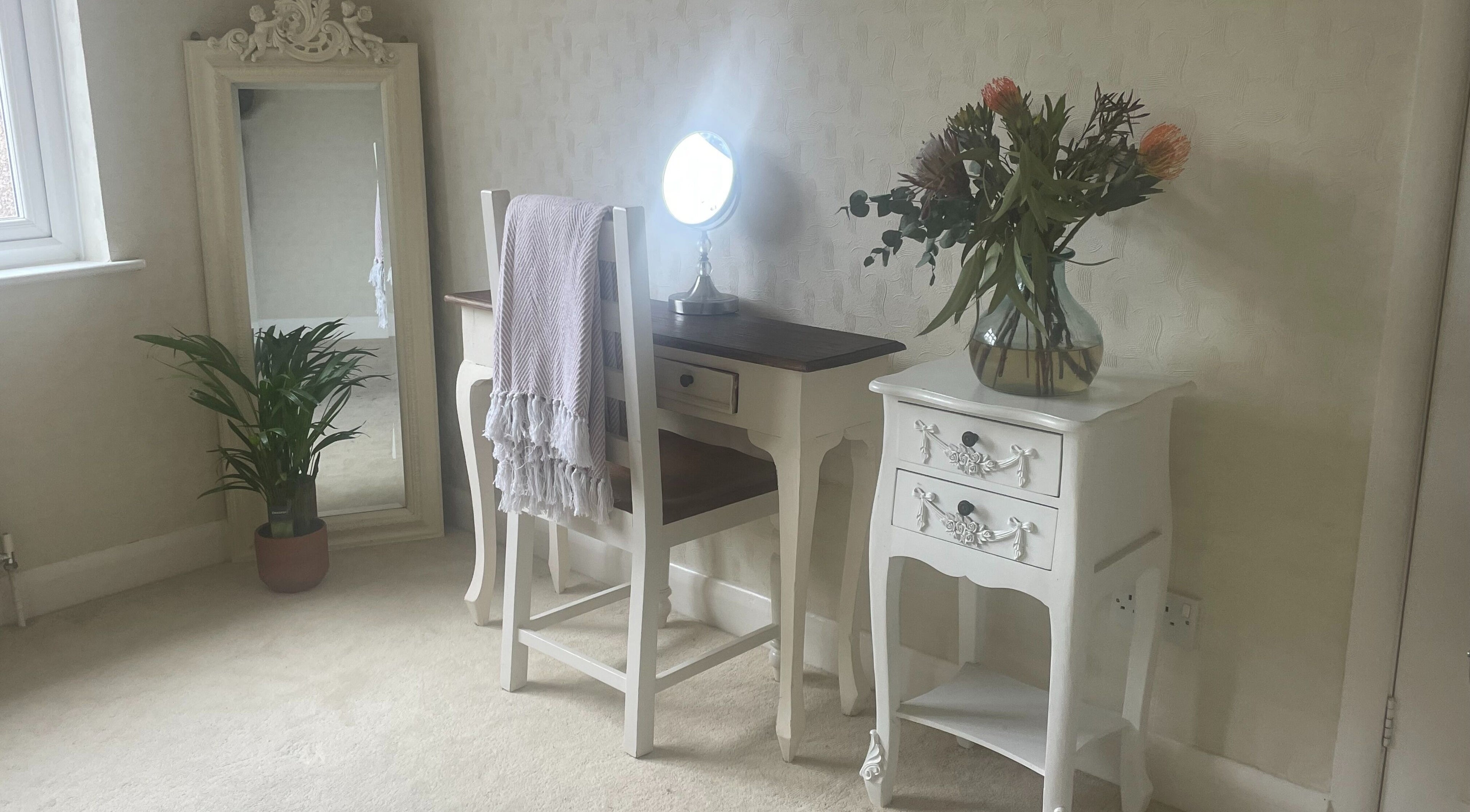 Charming vanity area at Temiluxe in Keynsham, England, GB with floral decor and mirror.