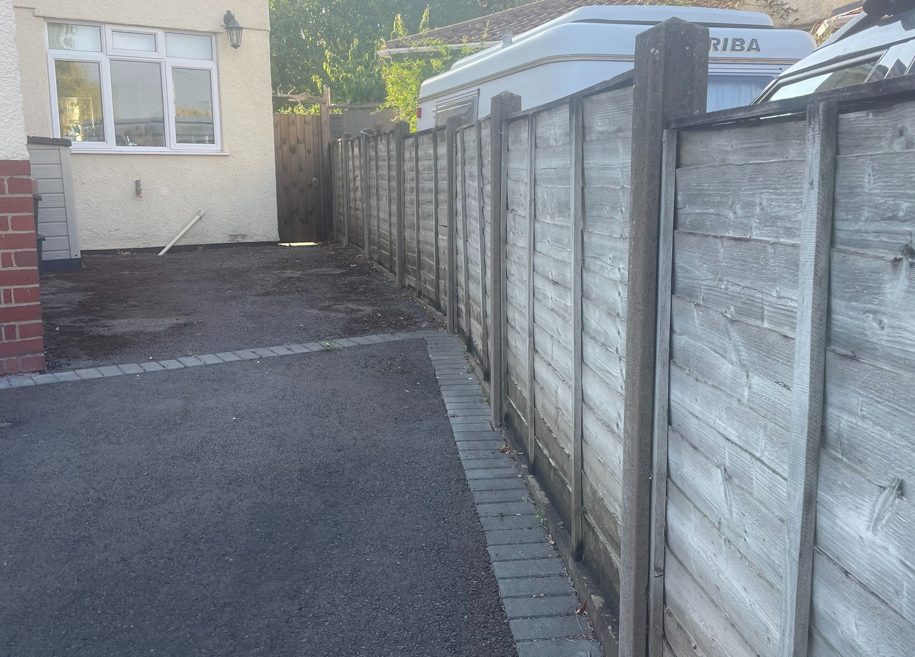 Driveway area at Temiluxe in Keynsham, England, GB featuring paved parking next to a wooden fence.