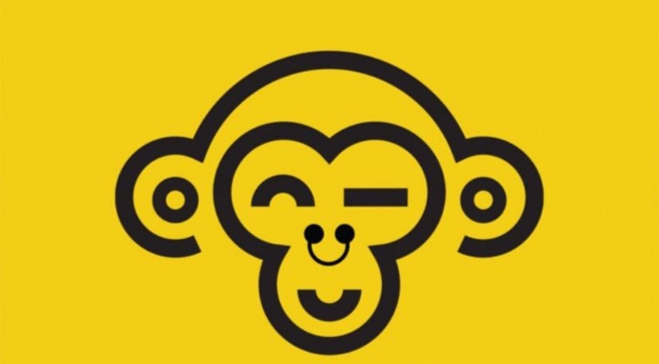 Cheerful monkey logo for Monkey Piercing in Salmiya, Hawalli Governorate, KW, on vibrant yellow background.