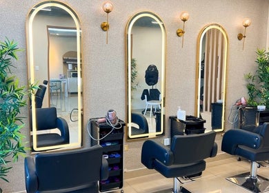 Interior elegante de Nodo.BI, Valencia, Carabobo, VE, con espejos iluminados y sillas de peluquería.