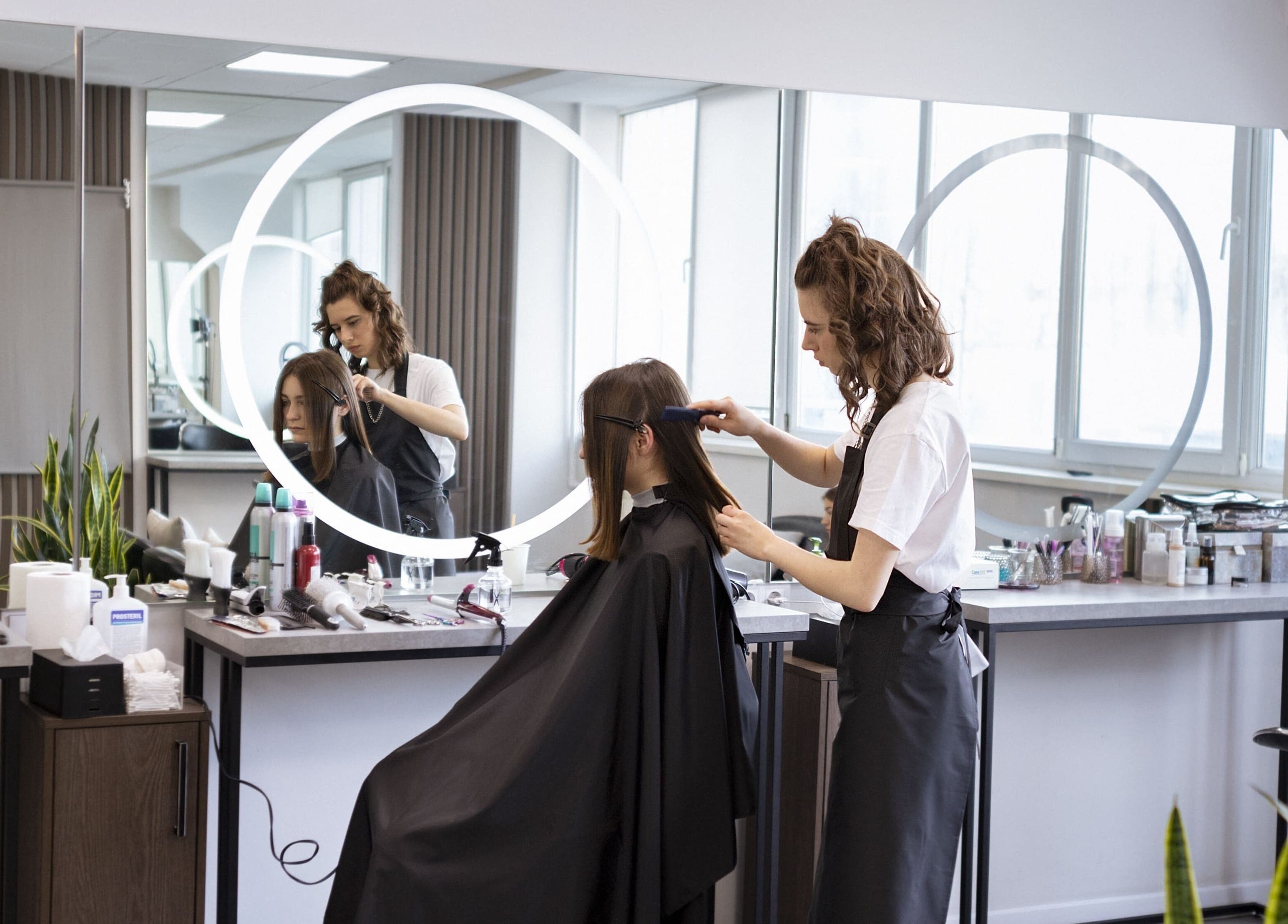 Estilista peinando a cliente en Nodo.BI, Valencia, Carabobo, VE. Espacio moderno de belleza.