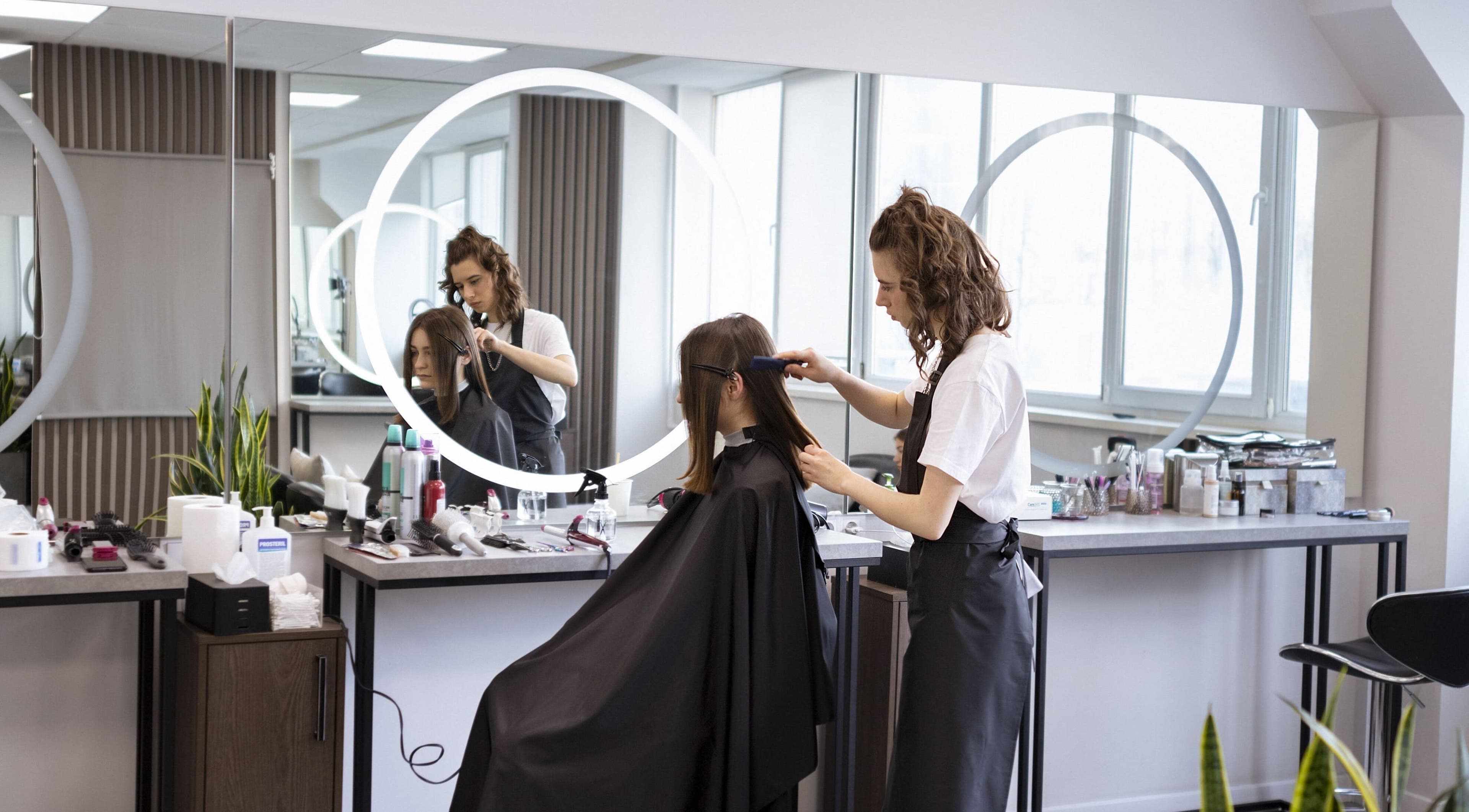 Estilista peinando a cliente en Nodo.BI, Valencia, Carabobo, VE. Espacio moderno de belleza.