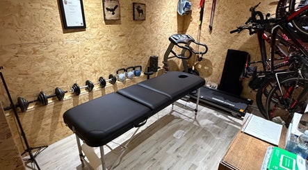 Therapy room at Everything Rehab, Northampton, England, GB featuring a massage table, weights, and treadmill.