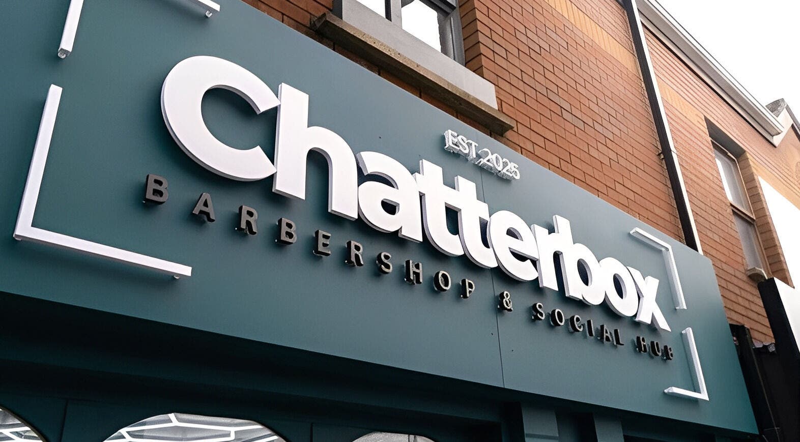 Exterior sign of Chatterbox barbershop in Lisburn, Northern Ireland, GB showcasing modern branding.