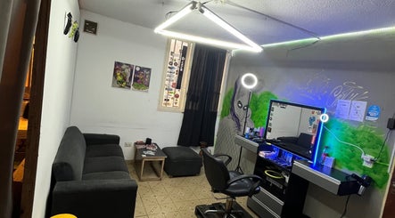 Interior moderno de BARBERS.THC en Rosario, AR, con silla de barbero iluminada y decoración artística.
