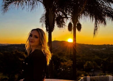 Woman enjoys beautiful sunset view at FVS Photography, Pretoria, Gauteng, ZA with palm trees.