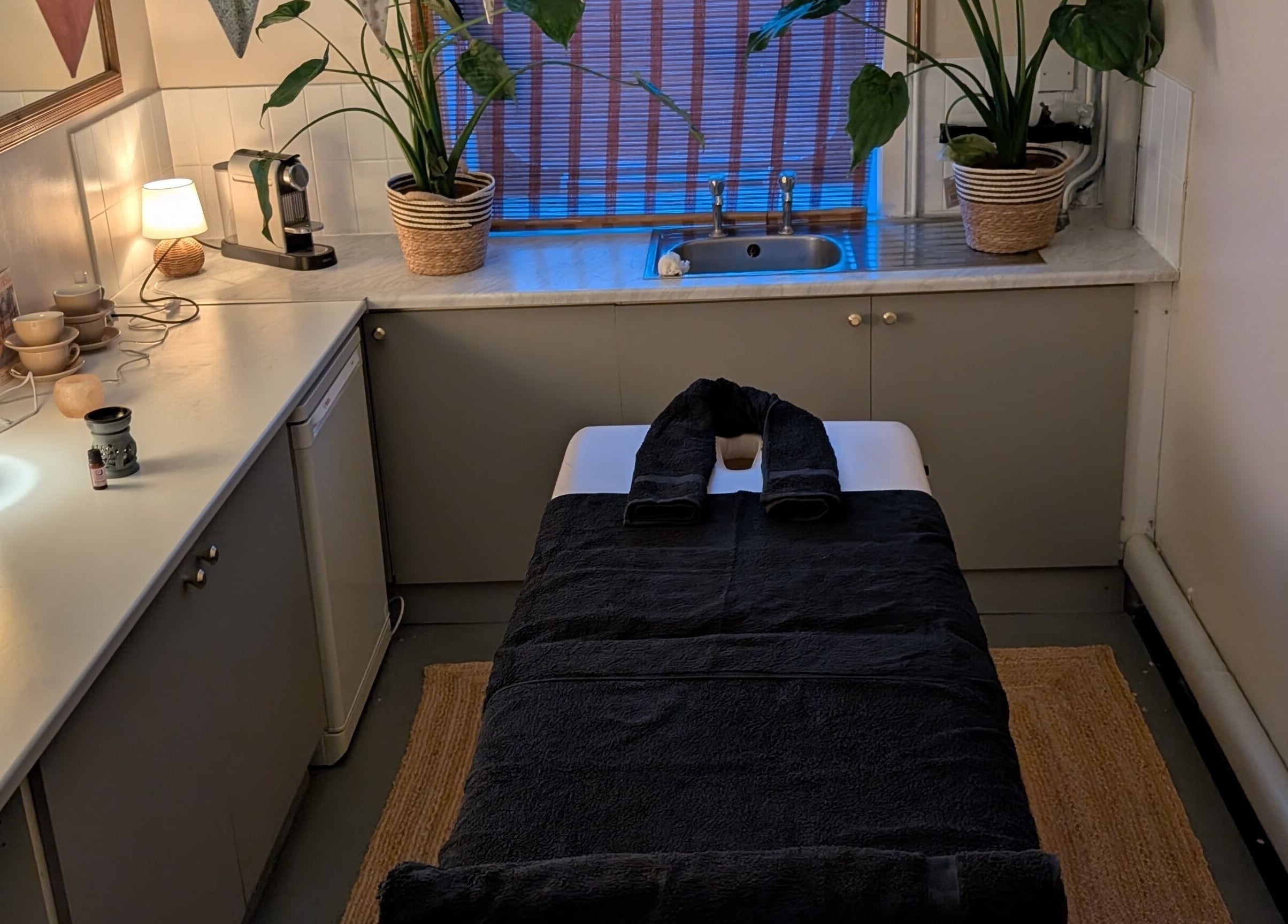 Tranquil massage room at Wave Massage Studio, Portland, England, GB, featuring cozy lighting and relaxing decor.