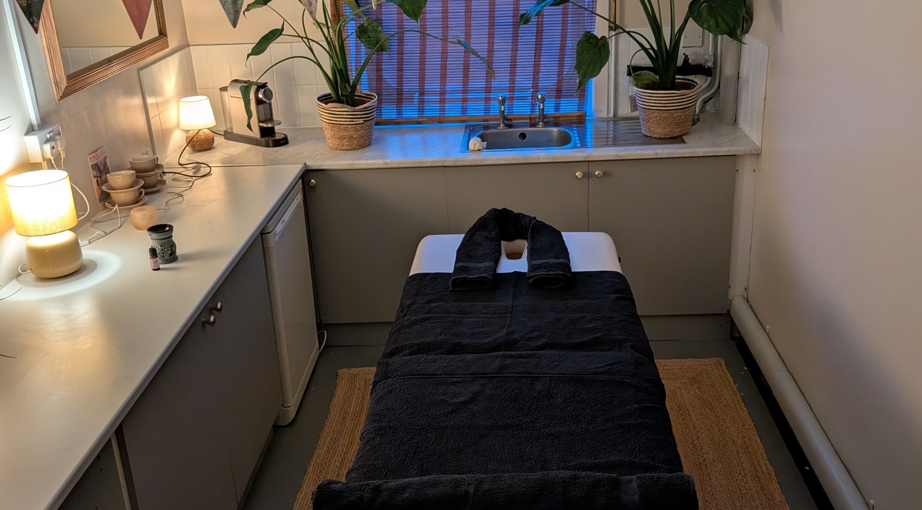 Tranquil massage room at Wave Massage Studio, Portland, England, GB, featuring cozy lighting and relaxing decor.