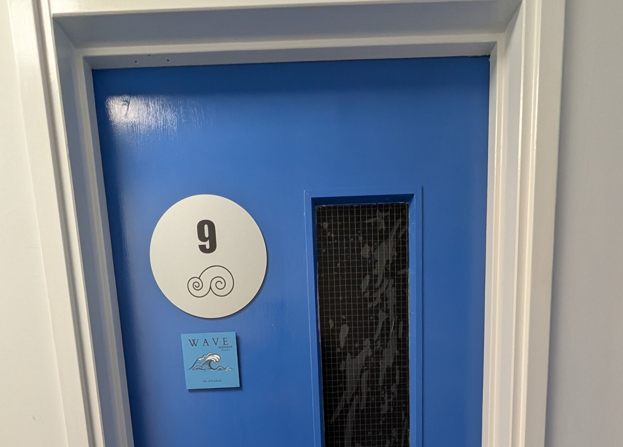 Entrance to Wave Massage Studio, Portland, England, GB, featuring a vibrant blue door with the number nine.