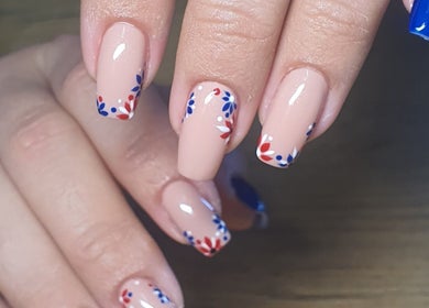 Elegant nail art with blue and red floral designs at Skulpted Nail Studio, George, Western Cape, ZA.