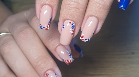 Elegant nail art with blue and red floral designs at Skulpted Nail Studio, George, Western Cape, ZA.