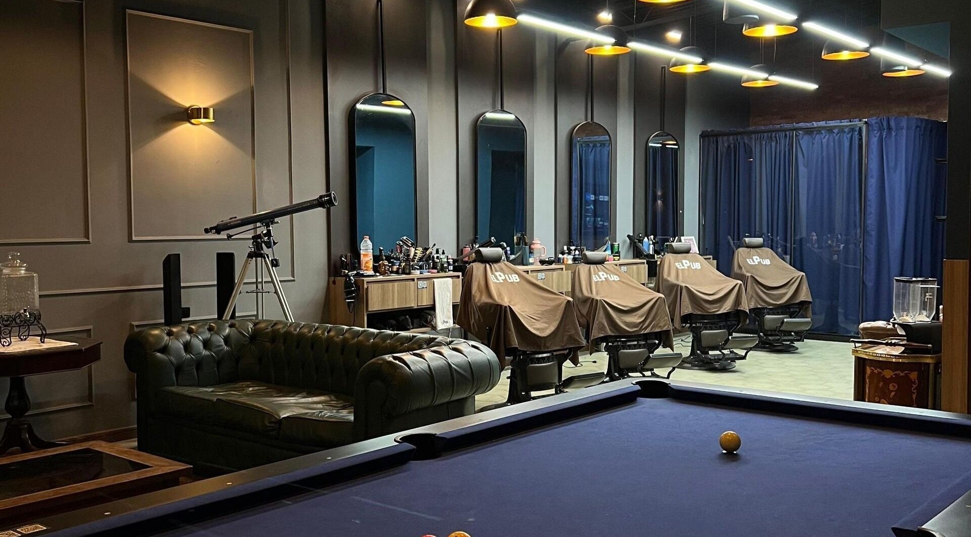 Interior del EL PUB STUDIO en Caracas, Miranda, VE, mostrando sillones de barbero y un ambiente acogedor.