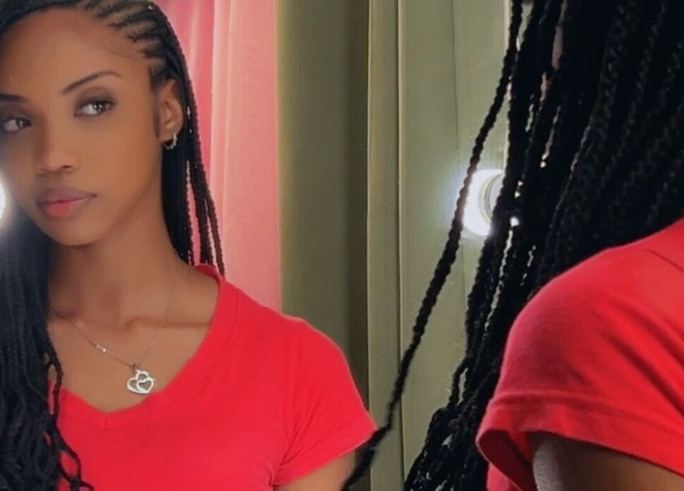 Woman with braided hair at JusstBraids, Oistins, Christ Church, BB, looking into a mirror.