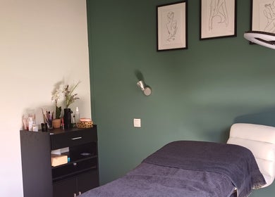 Sala de tratamiento en Curvas, Villemoustaussou, Occitanie, FR, con decoración moderna y una camilla.