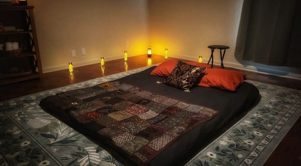 Cozy massage area at Claudia Gomez, LMT in Austin, Texas, US with pillows and warm candlelight.