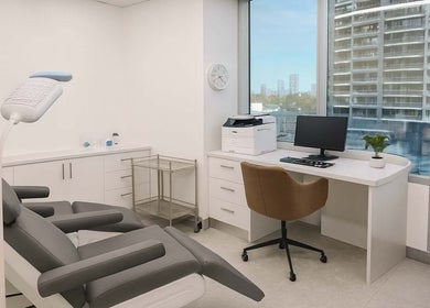 Modern treatment room at Gold Coast Hair Transplant Centre, Southport, Queensland, AU with a reclining chair and desk.
