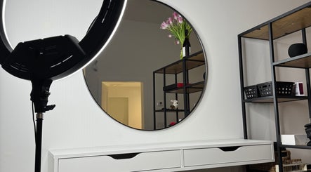 Современный интерьер WOW BEAUTY Studio в Бернаби, Британская Колумбия, CA с круглым зеркалом и освещением.
