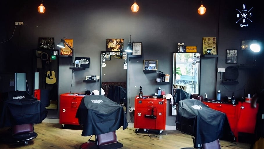 Stylish interior of Hombre Barbers (Eunos) with red chairs in Singapore, Singapore, SG.
