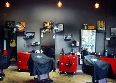 Stylish interior of Hombre Barbers (Eunos) with red chairs in Singapore, Singapore, SG.