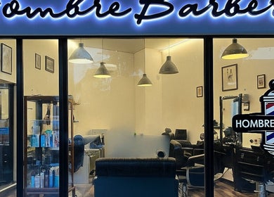 Hombre Barbers (Eunos) shopfront in Singapore, SG, showcasing sleek interior and barber pole sign.