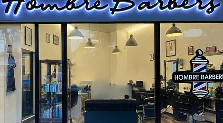 Hombre Barbers (Eunos) shopfront in Singapore, SG, showcasing sleek interior and barber pole sign.