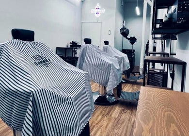 Interior view of Hombre Barbers (Bishan) in Singapore, showcasing modern barber chairs in a sleek setting.