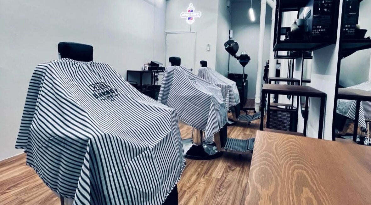 Interior view of Hombre Barbers (Bishan) in Singapore, showcasing modern barber chairs in a sleek setting.