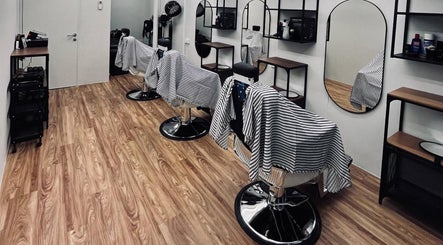 Interior of Hombre Barbers (Bishan) in Singapore showcasing stylish barber chairs and modern decor.