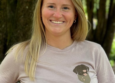 Smiling woman with blonde hair at The Grooming Studio, Ladoga, Indiana, US, wearing a dog print t-shirt.