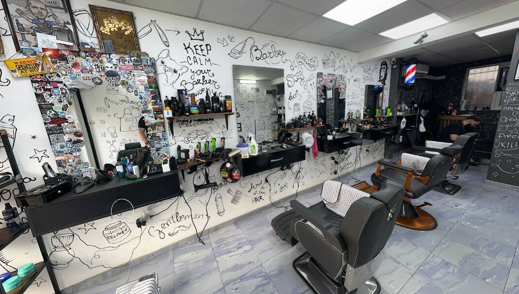Интериор на Evolution Barber Shop, Пловдив, с артистично изрисувани стени и оборудване за подстригване.
