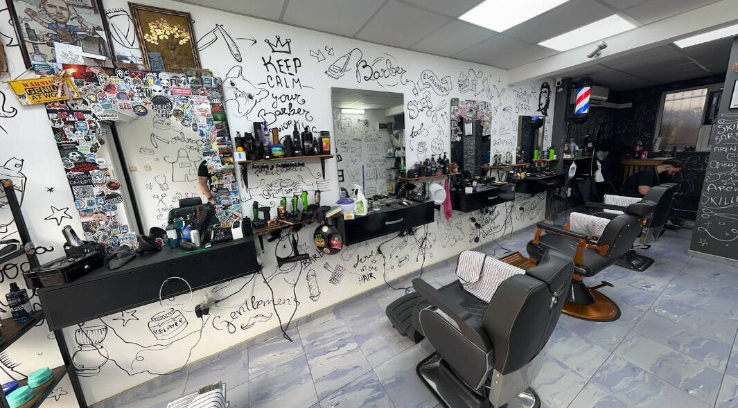 Интериор на Evolution Barber Shop, Пловдив, с артистично изрисувани стени и оборудване за подстригване.