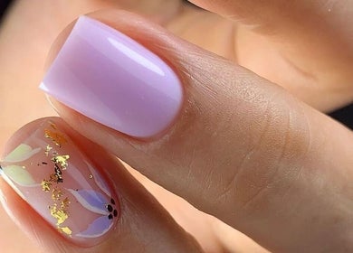 Arte de uñas en Afro Nails, US: diseño floral con dorado y esmalte lila.